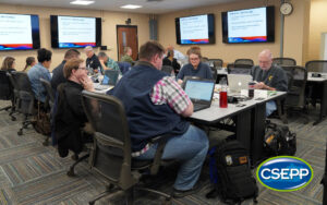 L-105 Class participants doing classwork at a table in the SEOC training room